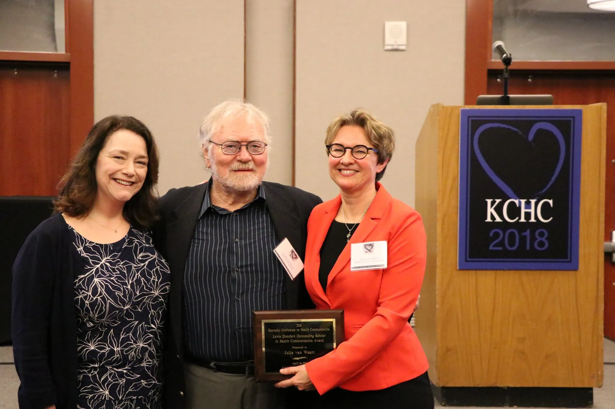 Nancy Harrington (left), KCHC director and associate dean for research in the College of Communication and Information, with KCHC Lewis Donohew Outstanding Scholar Julia van Weert (right), pose with the award’s namesake, the late Lewis Donohew, in 2018.