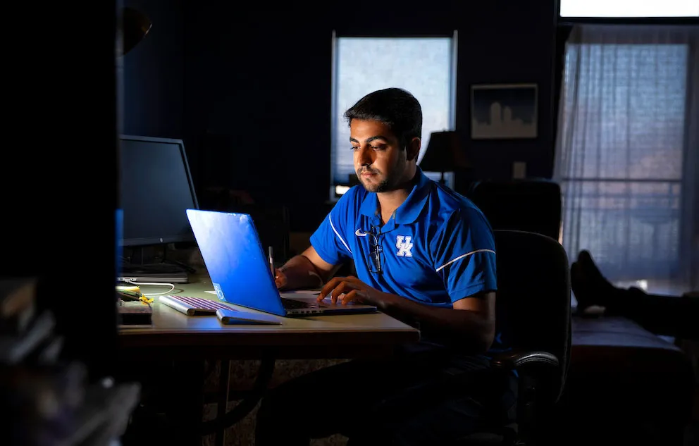 Student does homework at computer in a dark room