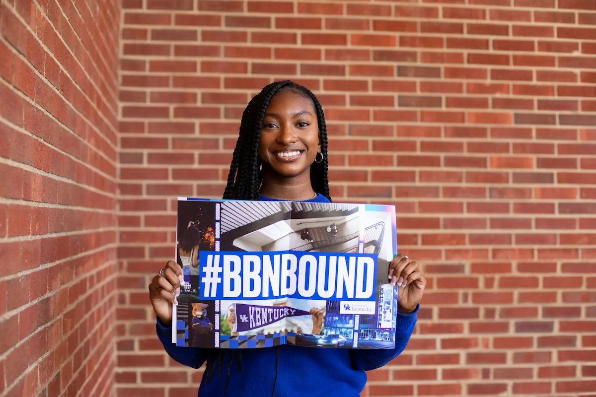 Admitted student holds up mailer reading #BBNBound