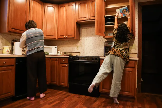 Cynthiana Democrat Regional Editor Kendall Staton gets a recipe from a shelf as she cooks dinner with her partner, Ethan Speer, on Tuesday, Jan. 23, 2024, in her home in Cynthiana, Kentucky. Photo by Abbey Cutrer.