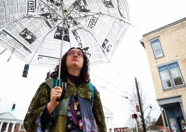 Cynthiana Democrat Regional Editor Kendall Staton holds a Lexington Herald-Leader umbrella on Wednesday, Jan. 24, 2024, outside the Democrat office in Cynthiana, Kentucky. Staton is one of the youngest newspaper editor’s in the country. Photo by Abbey Cutrer.