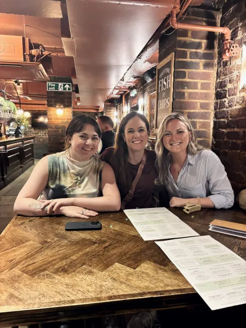 Alums Dani Jaffe and Emily Thomas at dinner with ISC assistant professor Sarah Geegan