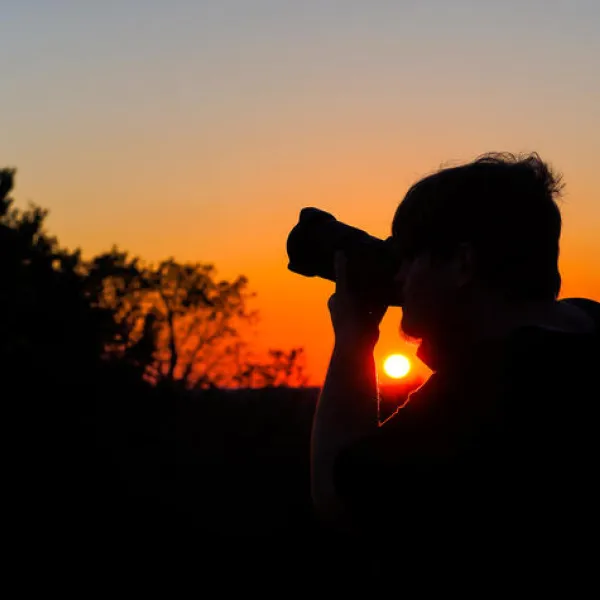 University of Kentucky journalism student Samuel Colmar lines up a shot at sunset during the Picture Kentucky Photojournalism Workshop in Frankfort, Kentucky, on Oct. 12, 2023. Photo by Carter Skaggs.